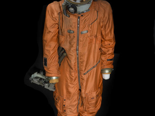 Orange body suit and white helmet with "CCCP" in red lettering across forehead on mannequin 