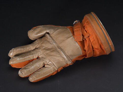 An orange glove, palm up.