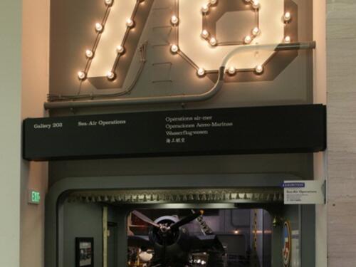 The entrance to a gallery with the numbers 76 illuminated above. 
