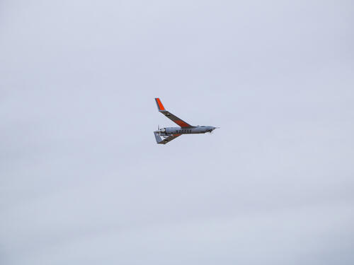 ScanEagle in flight with clouds in background.