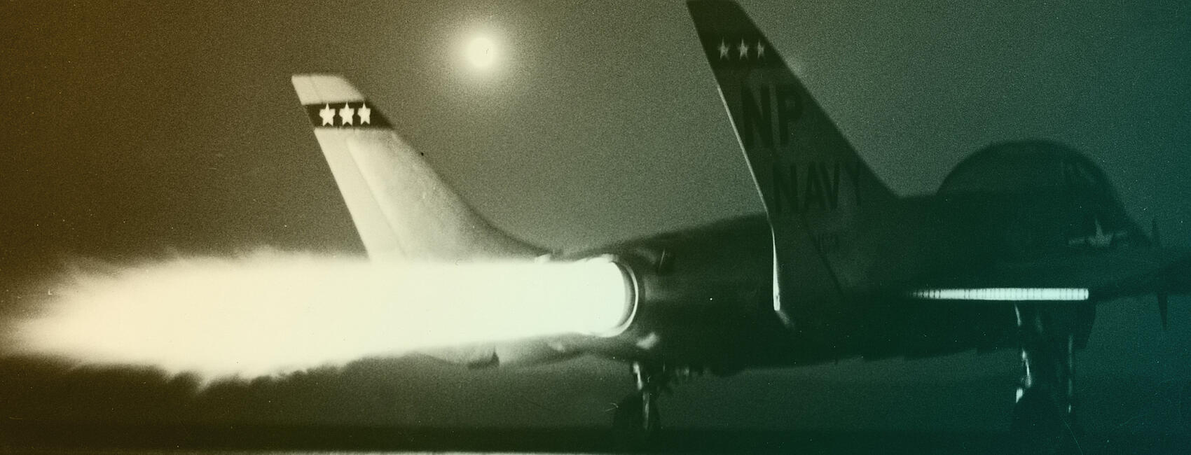 Fire streams out of a fighter jet's engine.
